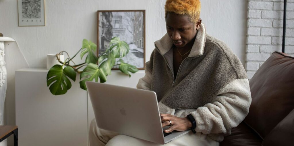 Person using a MacBook sat on sofa