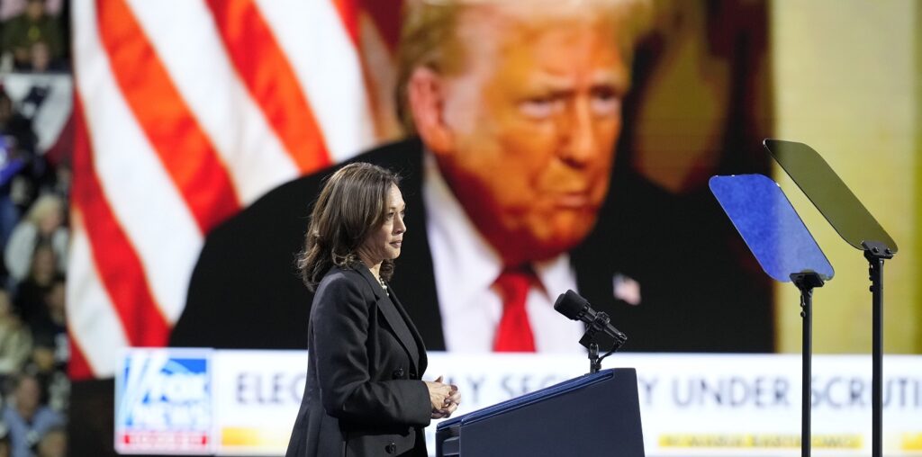 Kamala Harris speaks in front of an image of Donald Trump (Image: (AP/Jacquelyn Martin)