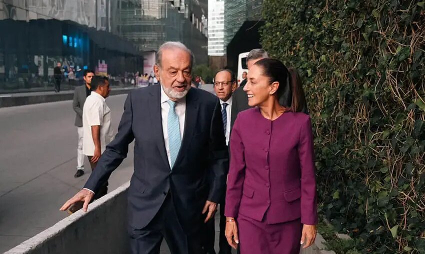 Carlos SLim and Claudia Sheinbaum walking and talking together on a sidewalk in Mexico City