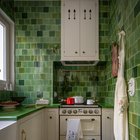 Compact kitchen clad with green tiles in a renovated 550 sq ft apartment in the 14th arrondissement of Paris, France. By Jessica Helgerson Interior Design.