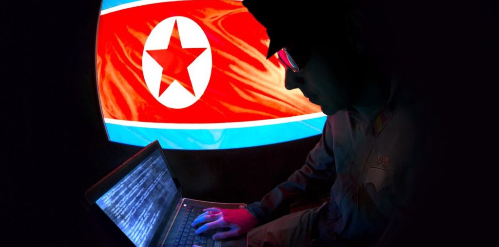 Hacker silhouette working on a laptop with North Korean flag on the background