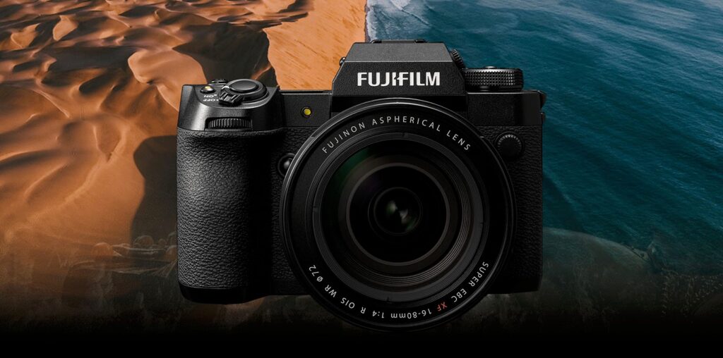 A Fujifilm camera with a Fujinon aspherical lens is displayed against a scenic background of sandy dunes meeting the ocean.