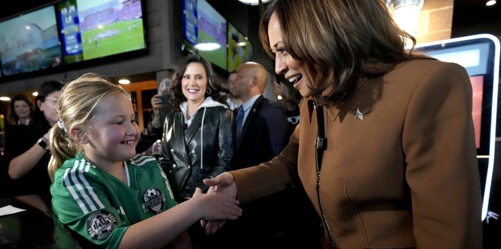 Democratic presidential nominee Vice President Kamala Harris, from right, and Michigan Gov. Gretchen Whitmer greet a young customer at the Trak Houz Bar & Grill after a campaign rally in Kalamazoo, Mich. (Jacquelyn Martin / The Associated Press)