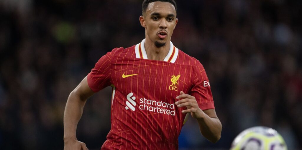 Trent Alexander-Arnold runs after a bouncing ball in his all-red Liverpool home kit.