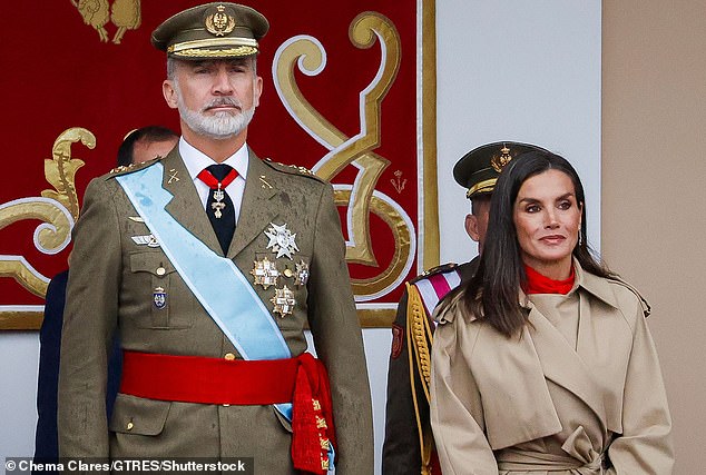 Queen Letizia of Spain braves the rain in stylish mac as she joins King Felipe at Columbus Day military parade in Madrid