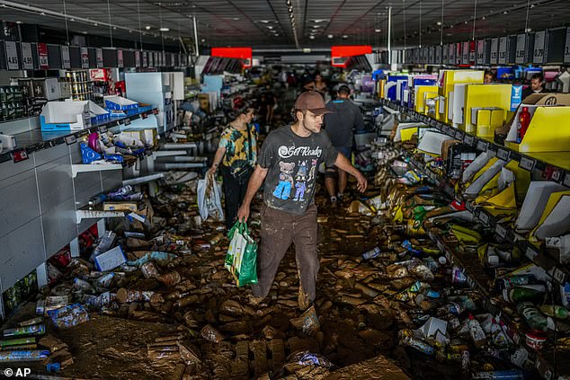 Shocking moment looters raid Valencia store as mobs hit shops while desperate families resort to rummaging through mud to find food in flooded supermarkets – as death toll passes 150