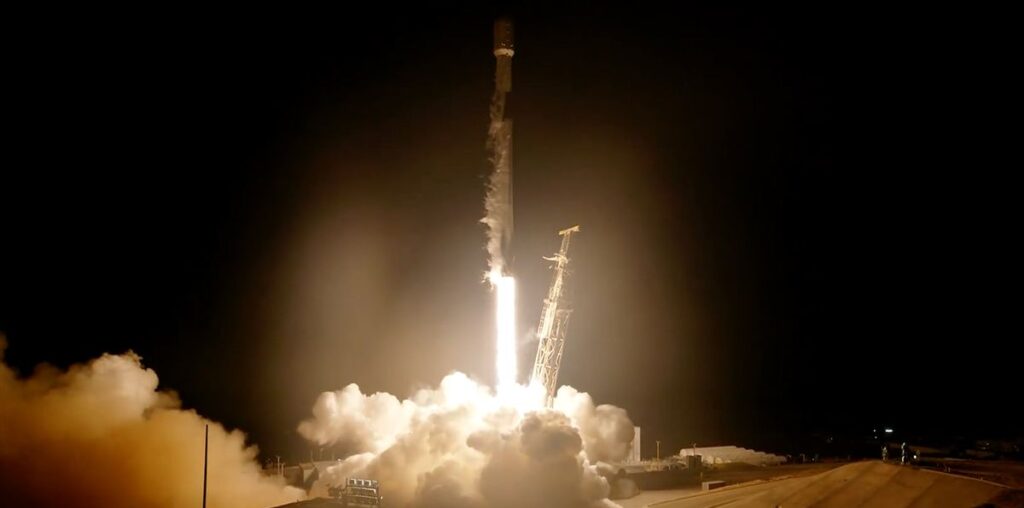 a black and white rocket launches into a dark night sky