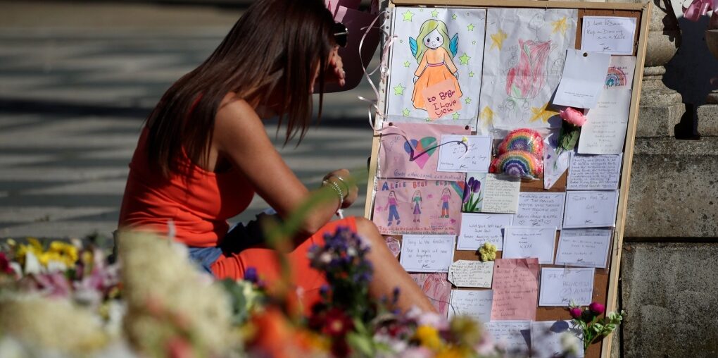 A woman looks at tributes that are left the Atkinson art centre in Southport, England, Aug. 11, 2024, after three young girls were killed in a knife attack at a Taylor Swift-themed holiday club. (AP Photo/Scott Heppell)