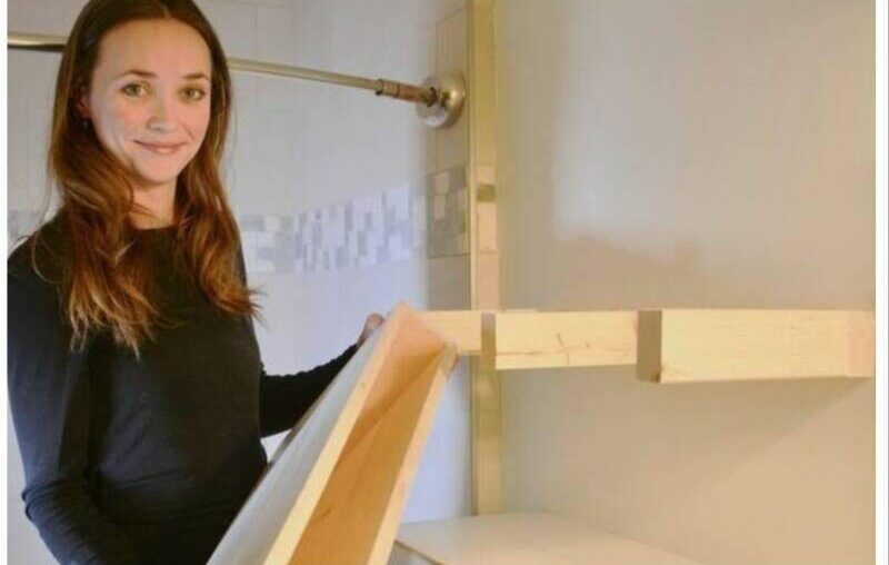 Woman holding wooden floating shelve.