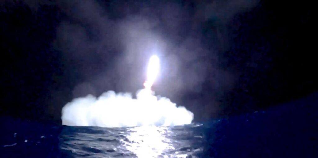 a rocket comes down for a splashdown in the ocean at night