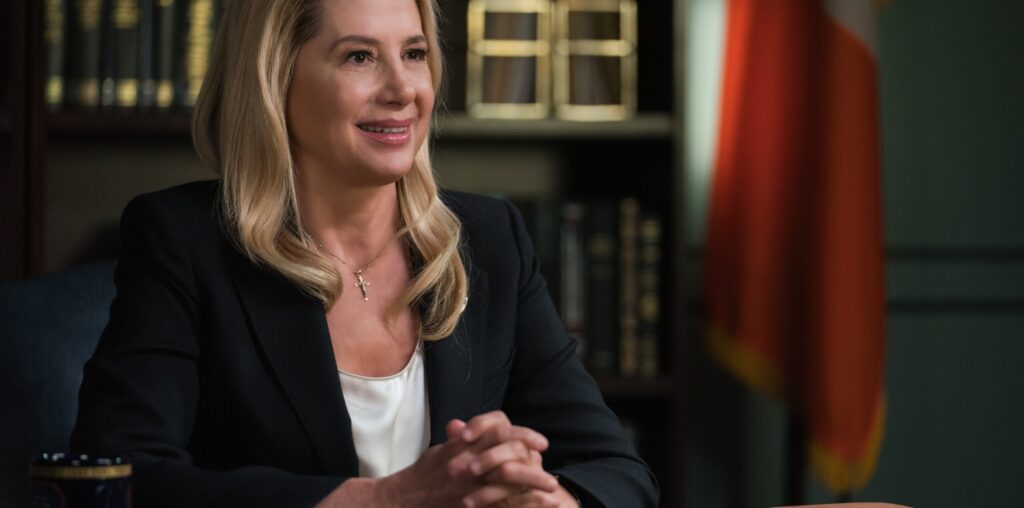 The new Fire Commissioner (Mira Sorvino) clasping her hands while sitting behind her desk on Blue Bloods Season 14 Episode 13