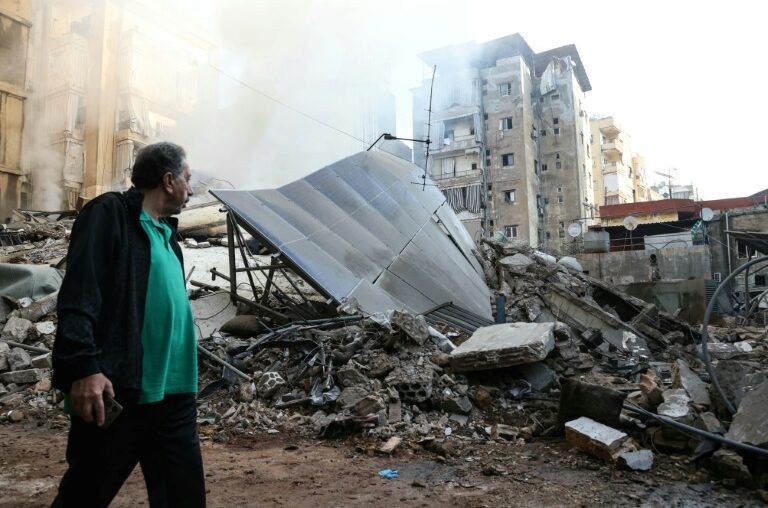 A man walks past the rubble of a building levelled by an Israeli air strike in Beirut's southern suburbs on Saturday