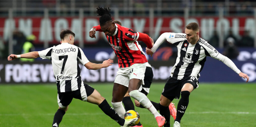 MILAN, ITALY - NOVEMBER 23: Rafael Leao of AC Milan is challenged by Francisco Conceicao and Teun Koopmeiners of Juventus during the Serie A match between AC Milan and Juventus at Stadio Giuseppe Meazza on November 23, 2024 in Milan, Italy. (Photo by Marco Luzzani/Getty Images)