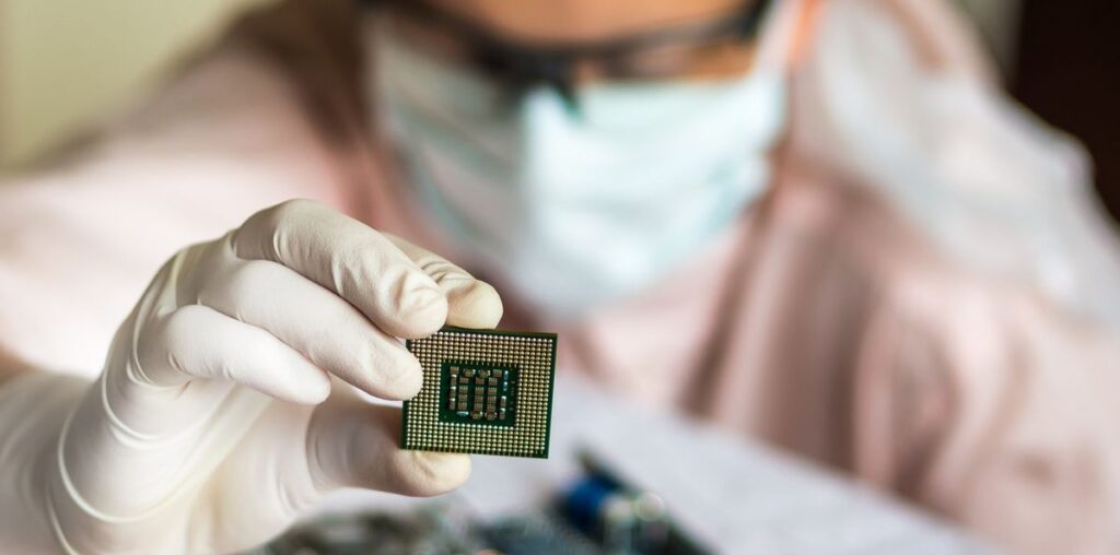 scientist holding microchip and checking electronic circuit