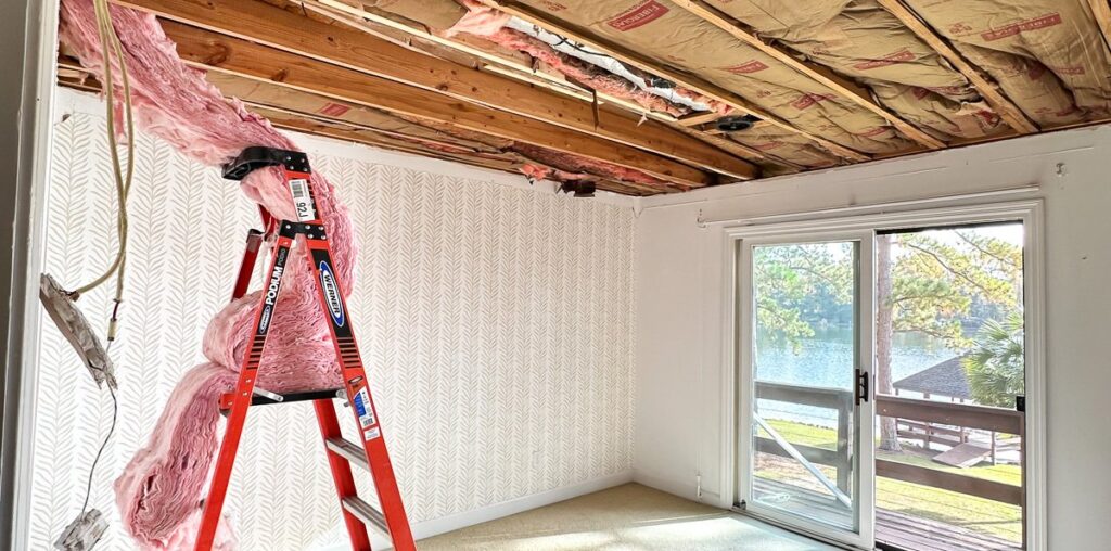 guest room with ceiling removed after a tree went through it.