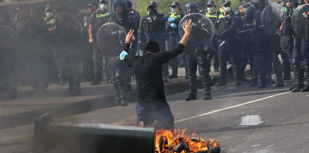 A protester faces police at the Land Forces protest, September 11, 2024 (Image: AAP/Con Chronis)