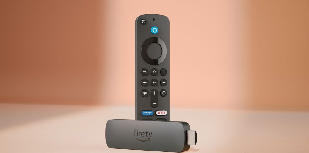 The Amazon Fire TV Stick 4K and remote control against a pinkish-brown background.