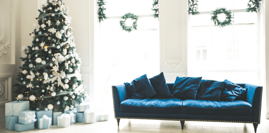 Blue velvet couch with Christmas tree in a living room.