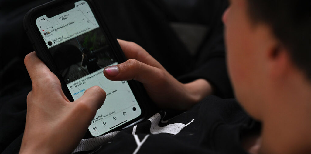 A teenager uses his mobile phone to access social media (Image: AAP/Dean Lewins)