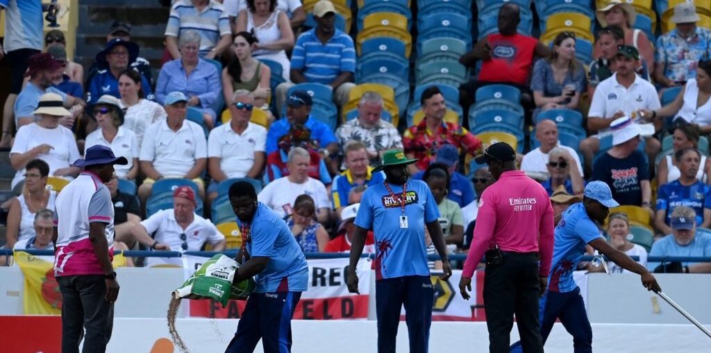 Groundstaff at Bridgetown in Barbados attempt to address a wet patch on the outfield during a rain delay in the first West Indies-England T20I